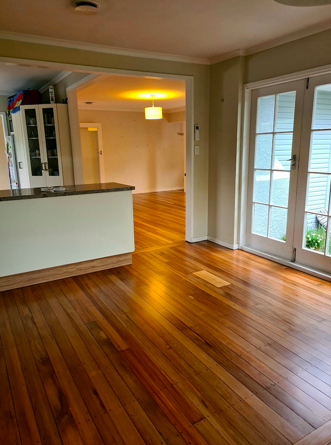 Open living and kitchen area with natural honey-toned timber floor sanding and waterborne polyurethane finish